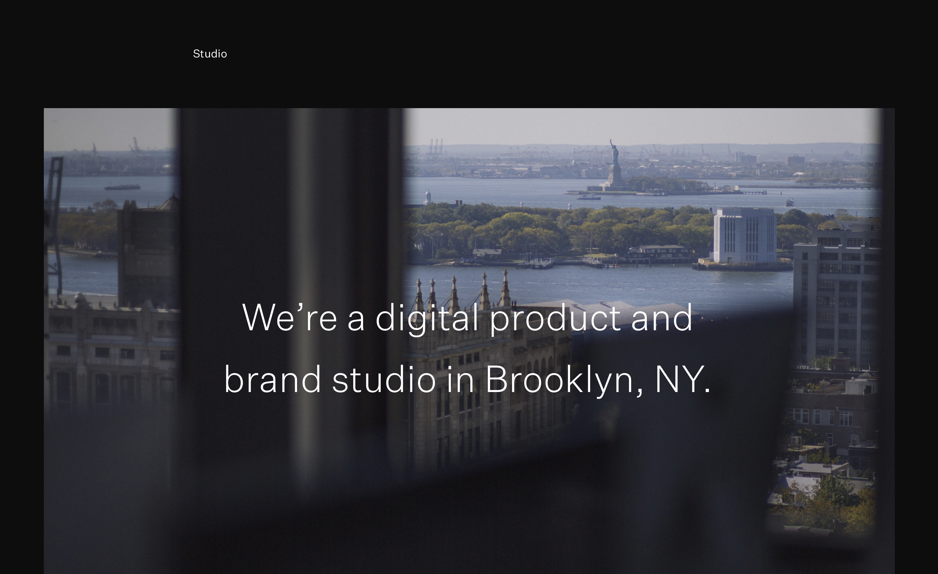 Studio. A photo of the Statue of Liberty as seen from the window of a 12th floor window in Downtown Brooklyn. White text reads "We're a digital product and brand studio in Brooklyn, NY."